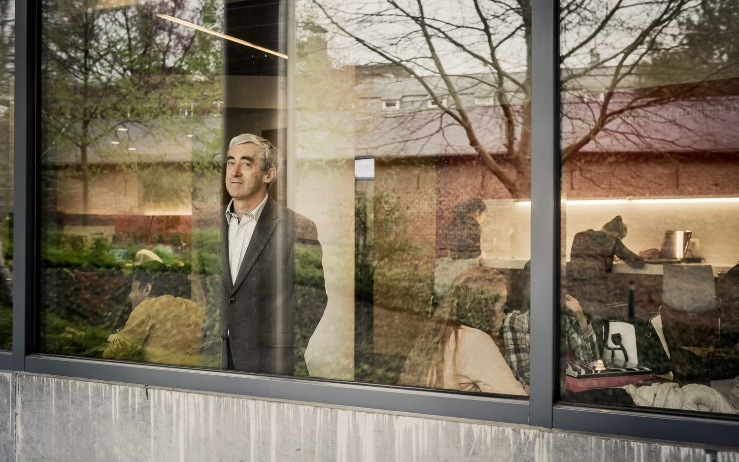De Grauwe steht am Fenster eines Klassenzimmers