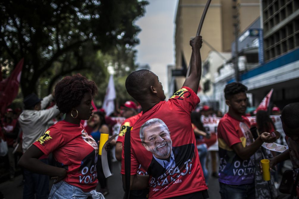 Demonstranten mit roten Lula-Shirts und Fahnen in den Strassen von Curitiba.