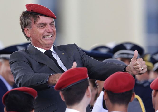 Jair Bolsonaro grinst mit rotem Beret und hochgehaltenen Daumen am Tag der Armee in Brasilia.