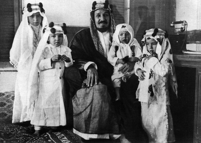 Historisch schwarz-weiss Fotografie zeigt den ersten König Saudiarabiens mit vier seiner Kinder.