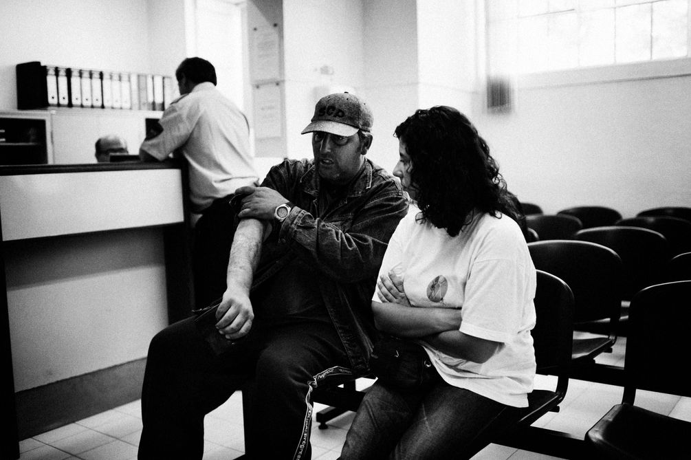 Eine Helferin wartet mit einem drogensüchtigen Patienten im Wartezimmer einer medizinischen Versorgungseinrichtung. 