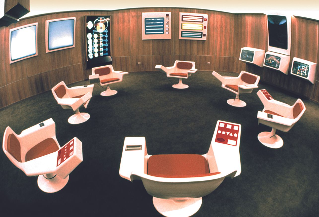 Blick in den Operationsraum, mit futuristischen Stühlen und Monitoren an der Wand
