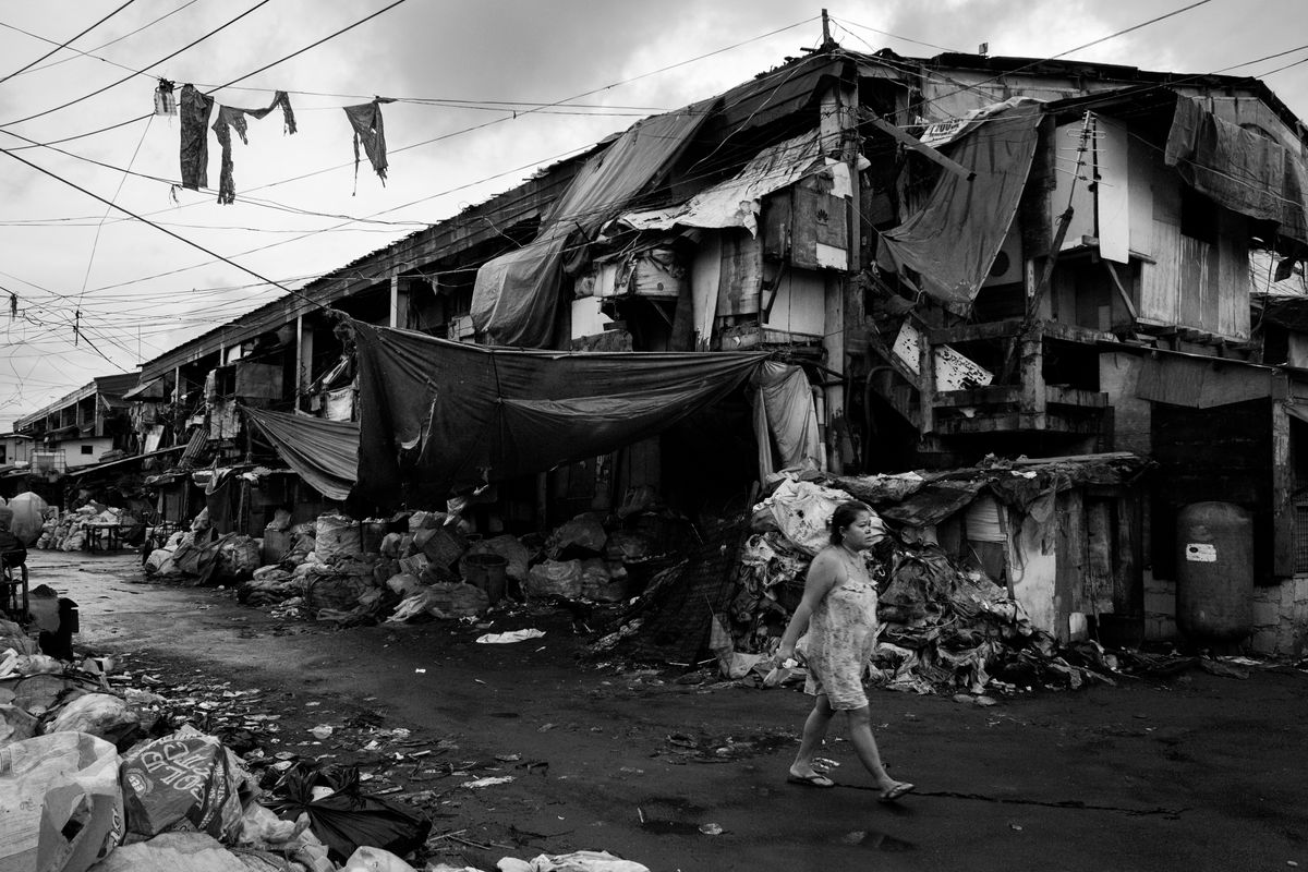 Eine Frau geht durch die Strassen eines Slums