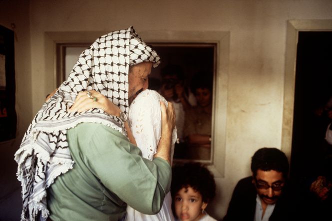Arafat tröstet eine Frau in seinen Armen