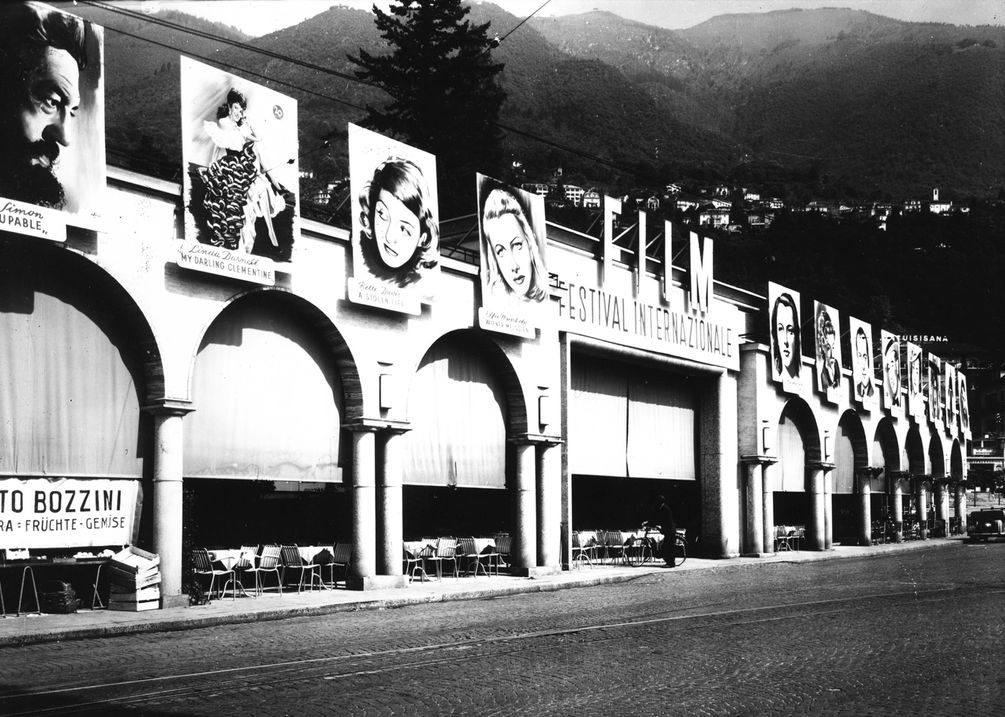 historische Aufnahme von Filmplakaten an den Bögen der Piazza Grande
