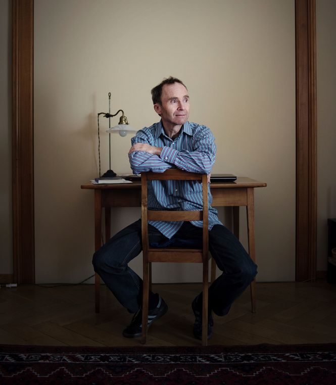 Der Psychiater Petter Gasser sitzt auf einem Stuhl in seiner Praxis.