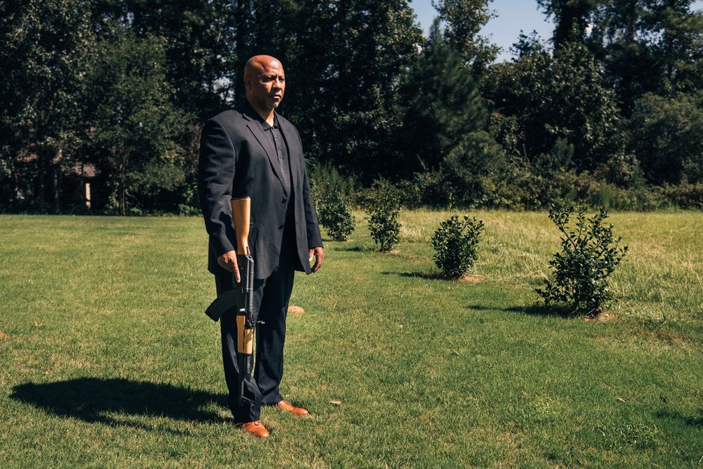 Philip Smith steht mit dem Gewehr in seinem gepflegten Garten