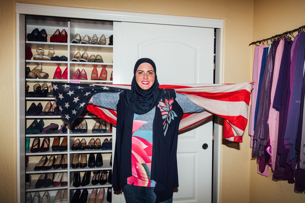 Deedra Abboud steht vor ihrem Schuhgestell und umhüllt sich mit der USA Flagge