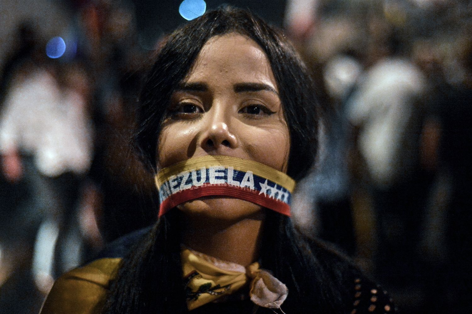 Demonstratin mit einer Bande über ihrem Mund mit der Aufschrift Venezuela