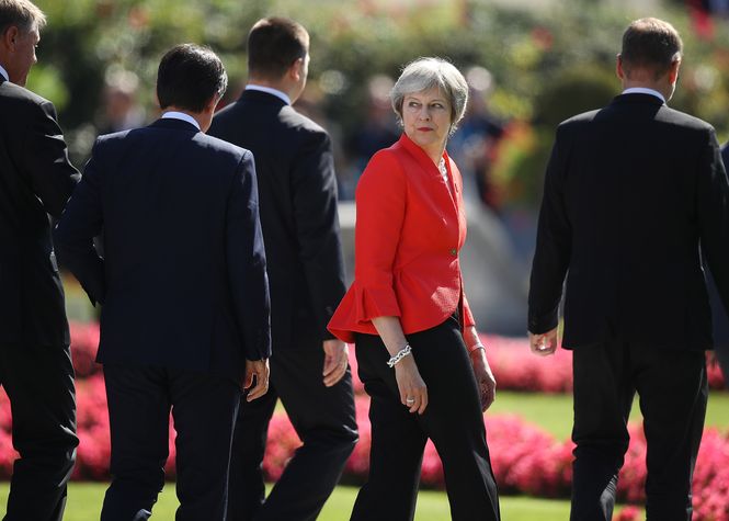Theresa May zwischen ihren männlichen Kollegen am EZ-Gipfel in Salzburg. May trägt einen rotem Blazer und dreht sich als einzige nach hinten blickend zurück.
