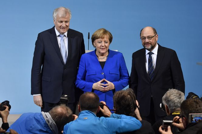 Merkel steht mit Horst Seehofer und Martin Schulz vor Pressefotografen